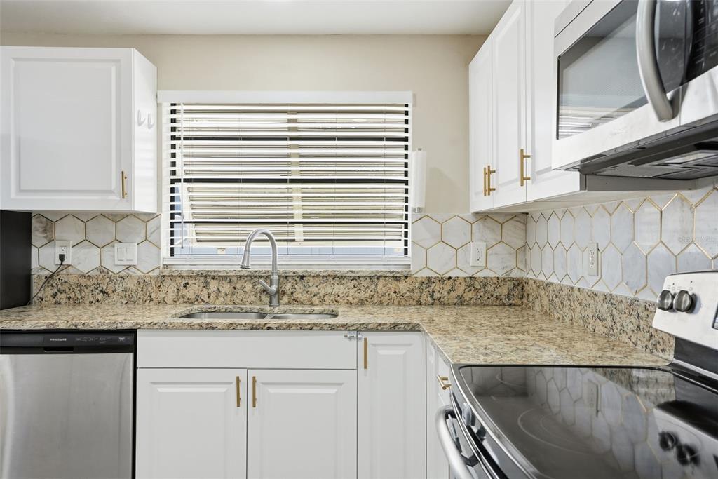 7026 Whitethorn Court Port Richey, FL 34668 - Photo 18 of 45 a kitchen with granite countertop a sink and a stove
