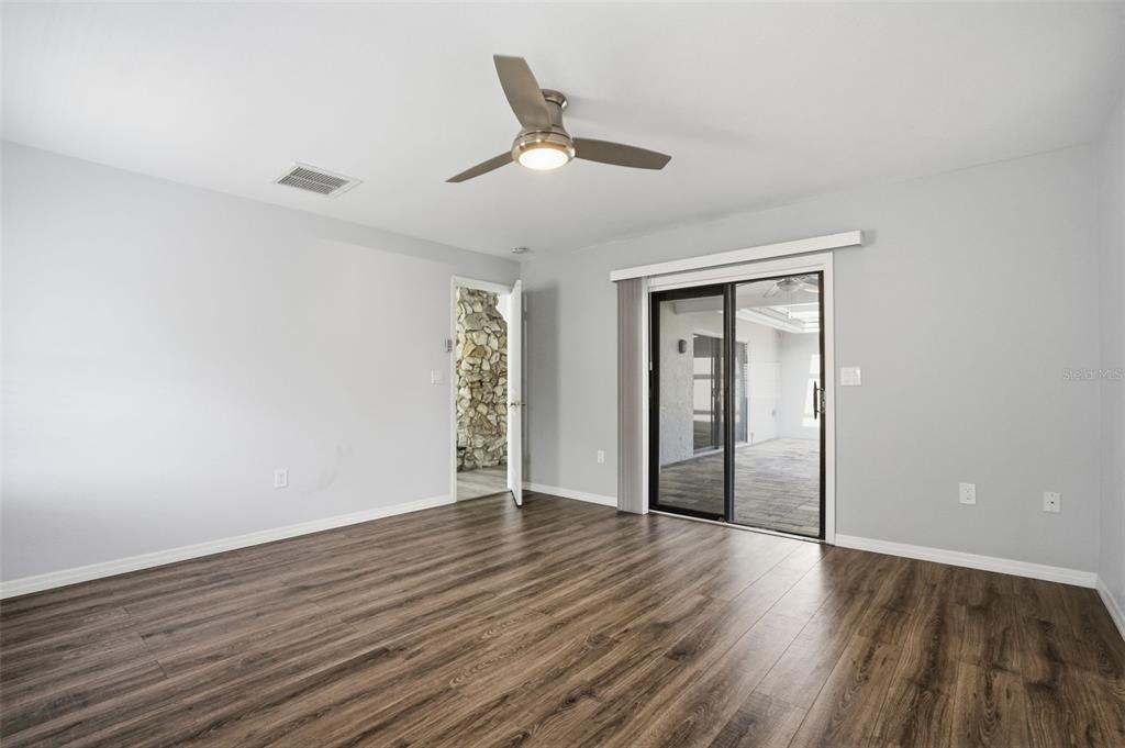 7026 Whitethorn Court Port Richey, FL 34668 - Photo 26 of 45 a view of an empty room with wooden floor and a ceiling fan