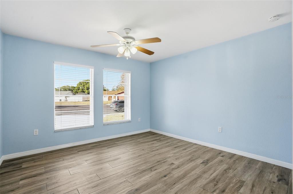7026 Whitethorn Court Port Richey, FL 34668 - Photo 32 of 45 a view of an empty room with chandelier fan and wooden floor