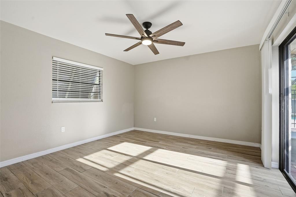 7026 Whitethorn Court Port Richey, FL 34668 - Photo 35 of 45 a view of empty room with wooden floor and fan