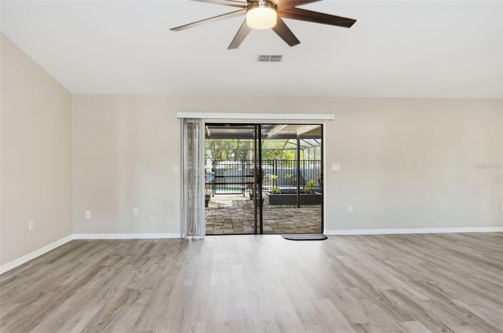 7026 Whitethorn Court Port Richey, FL 34668 - Photo 8 of 45 an empty room with wooden floor fan and windows