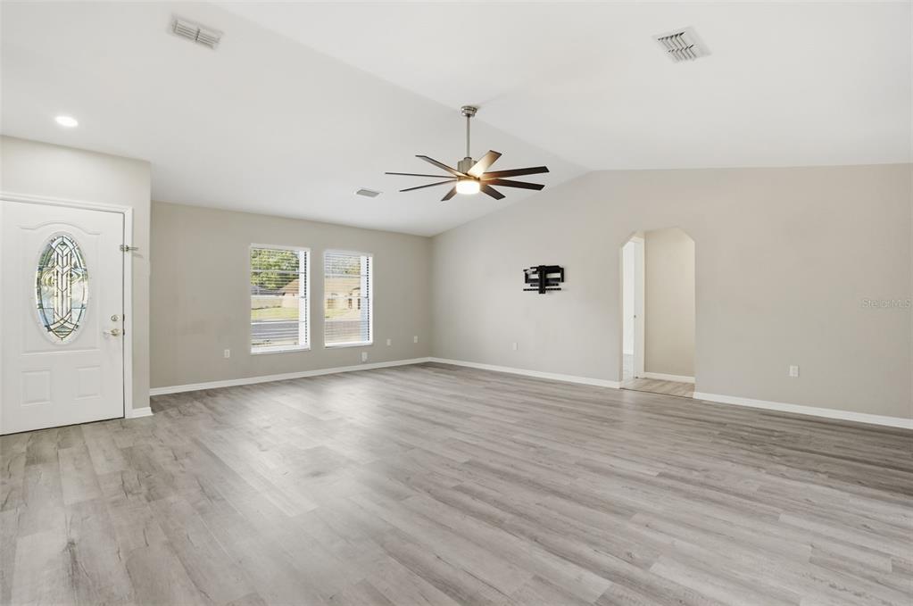 7026 Whitethorn Court Port Richey, FL 34668 - Photo 9 of 45 wooden floor in an empty room with a window