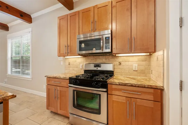 a kitchen with granite countertop cabinets stainless steel appliances and a counter space
