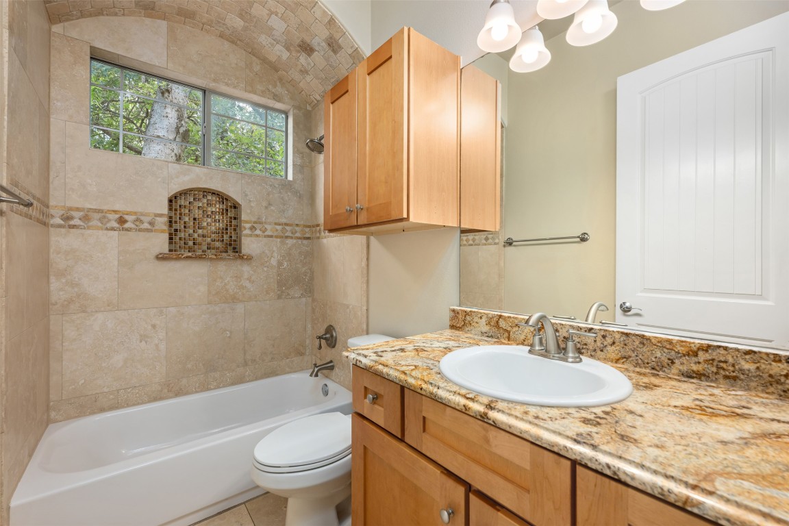 303 Zennia Street Austin, TX 78751 - Photo 20 of 40 a bathroom with a granite countertop sink a toilet and a bathtub