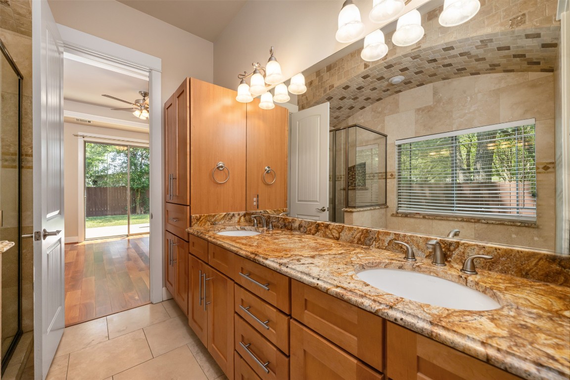 303 Zennia Street Austin, TX 78751 - Photo 22 of 40 a spacious bathroom with a granite countertop double vanity sink a mirror and a shower