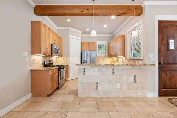 a large kitchen with stainless steel appliances kitchen island granite countertop a sink and cabinets
