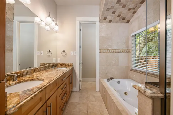 a bathroom with a tub sink and mirror