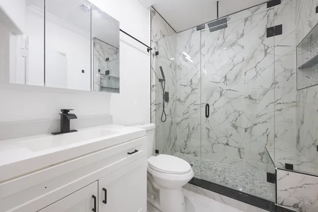 a bathroom with a sink a toilet and a shower