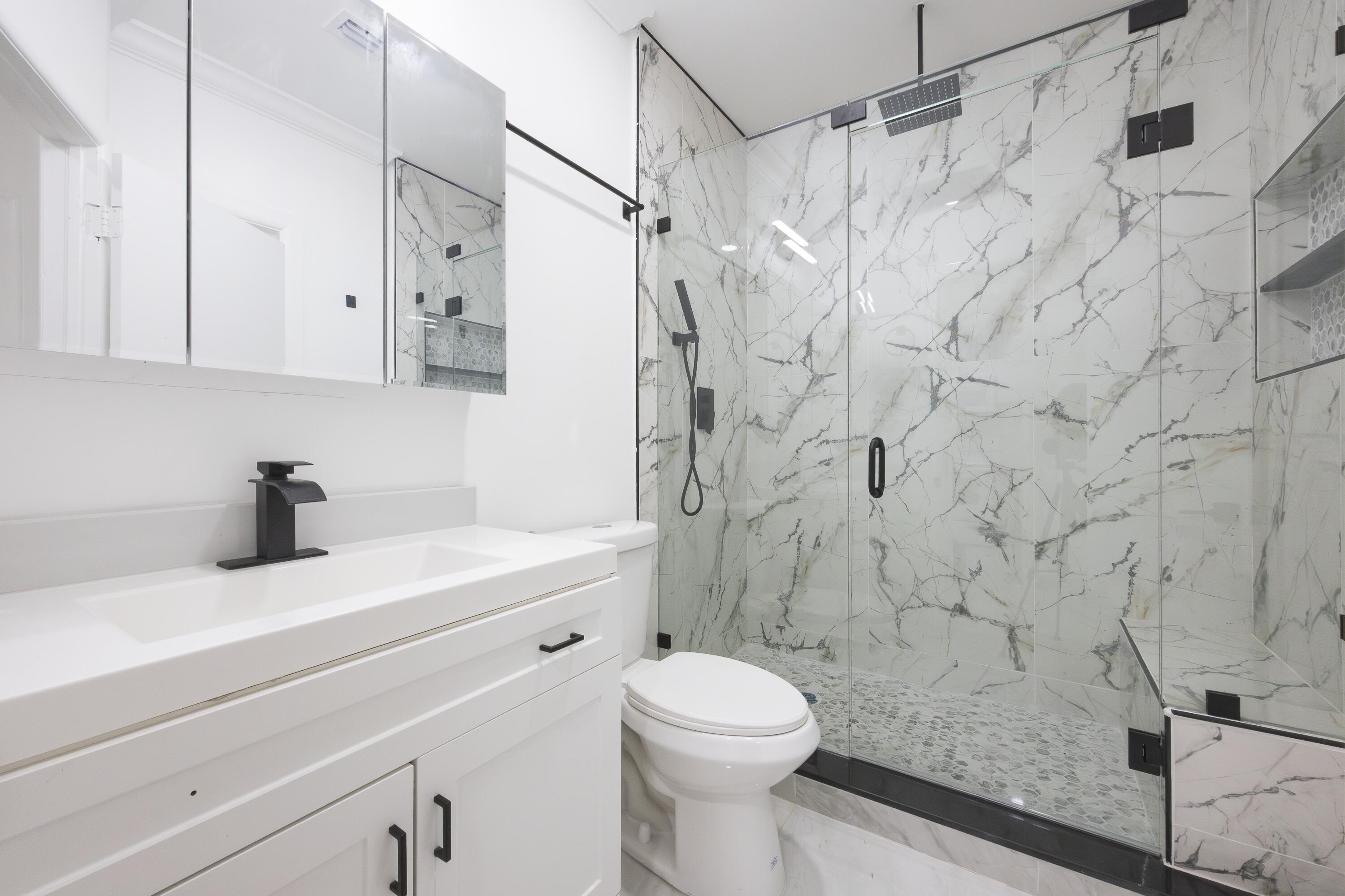 a bathroom with a sink a toilet and a shower