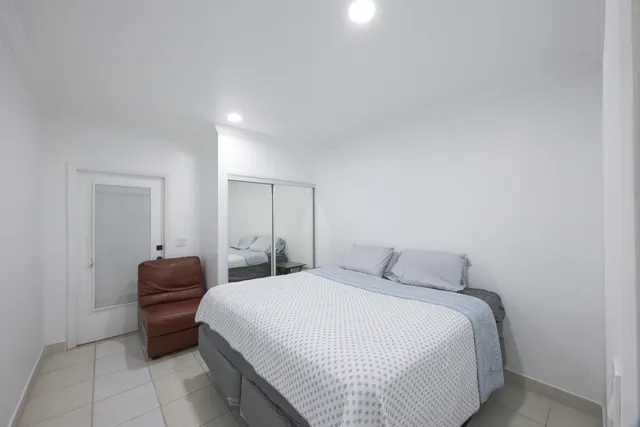 a bedroom with a bed and a mirror