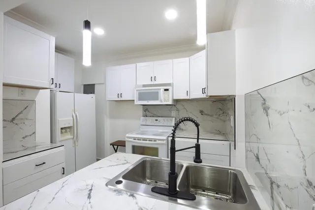 a kitchen with white cabinets and stainless steel appliances