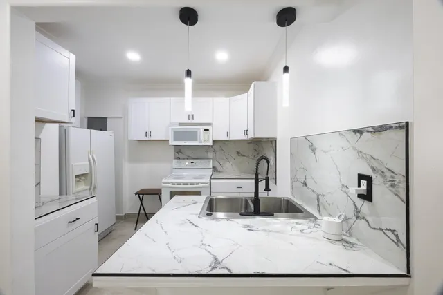 a kitchen with stainless steel appliances kitchen island sink refrigerator and stove