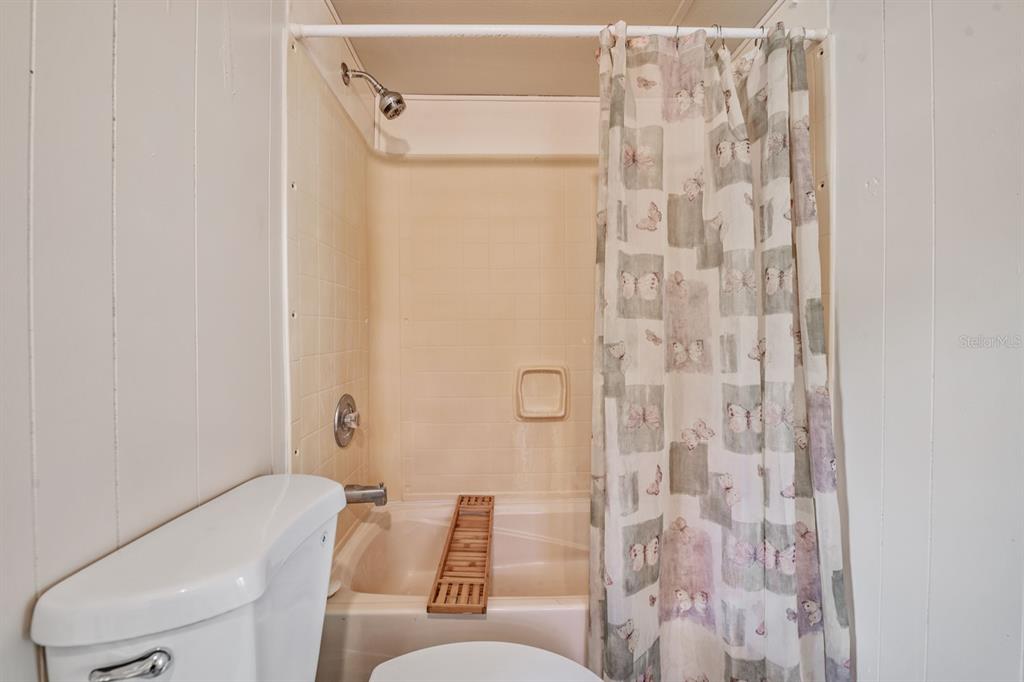 9739 Ray Street Hudson, FL 34669 - Photo 27 of 36 a bathroom with a toilet and shower curtain