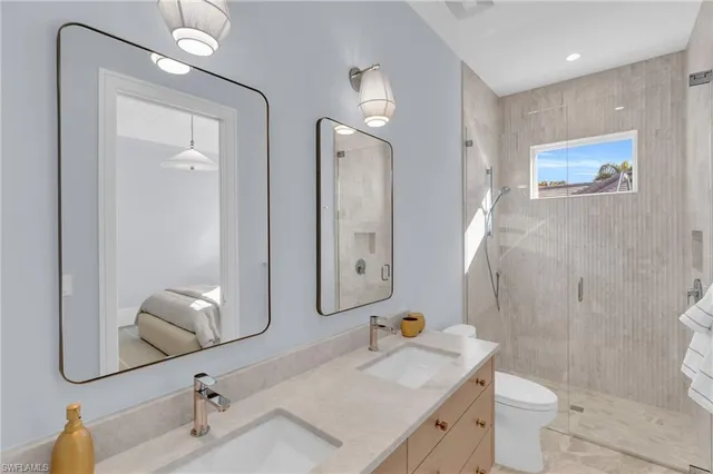 a bathroom with a sink vanity mirror and toilet