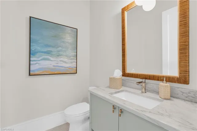 a bathroom with a granite countertop sink a toilet and a mirror