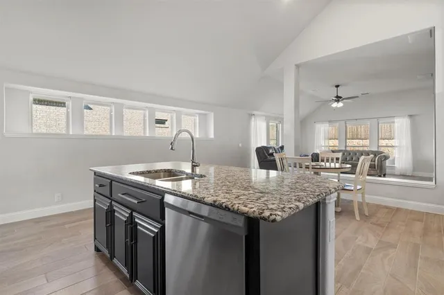 a kitchen with stainless steel appliances granite countertop a sink stove and wooden floor