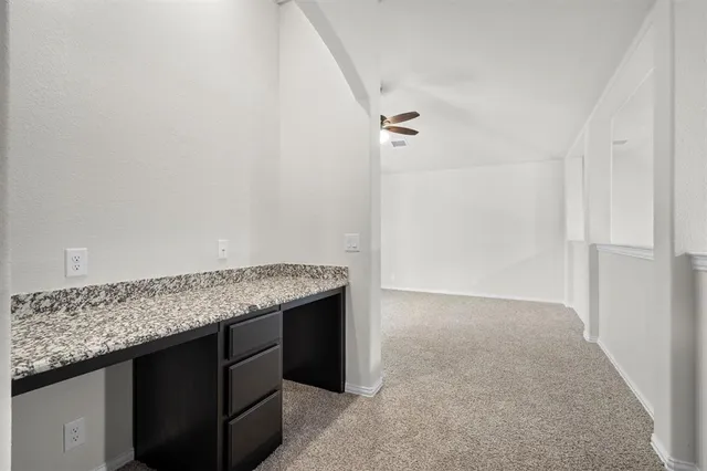 a utility room with granite countertop cabinets and utility room