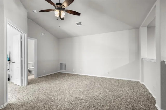 an empty room with closet and a chandelier fan