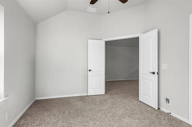an empty room with chandelier fan