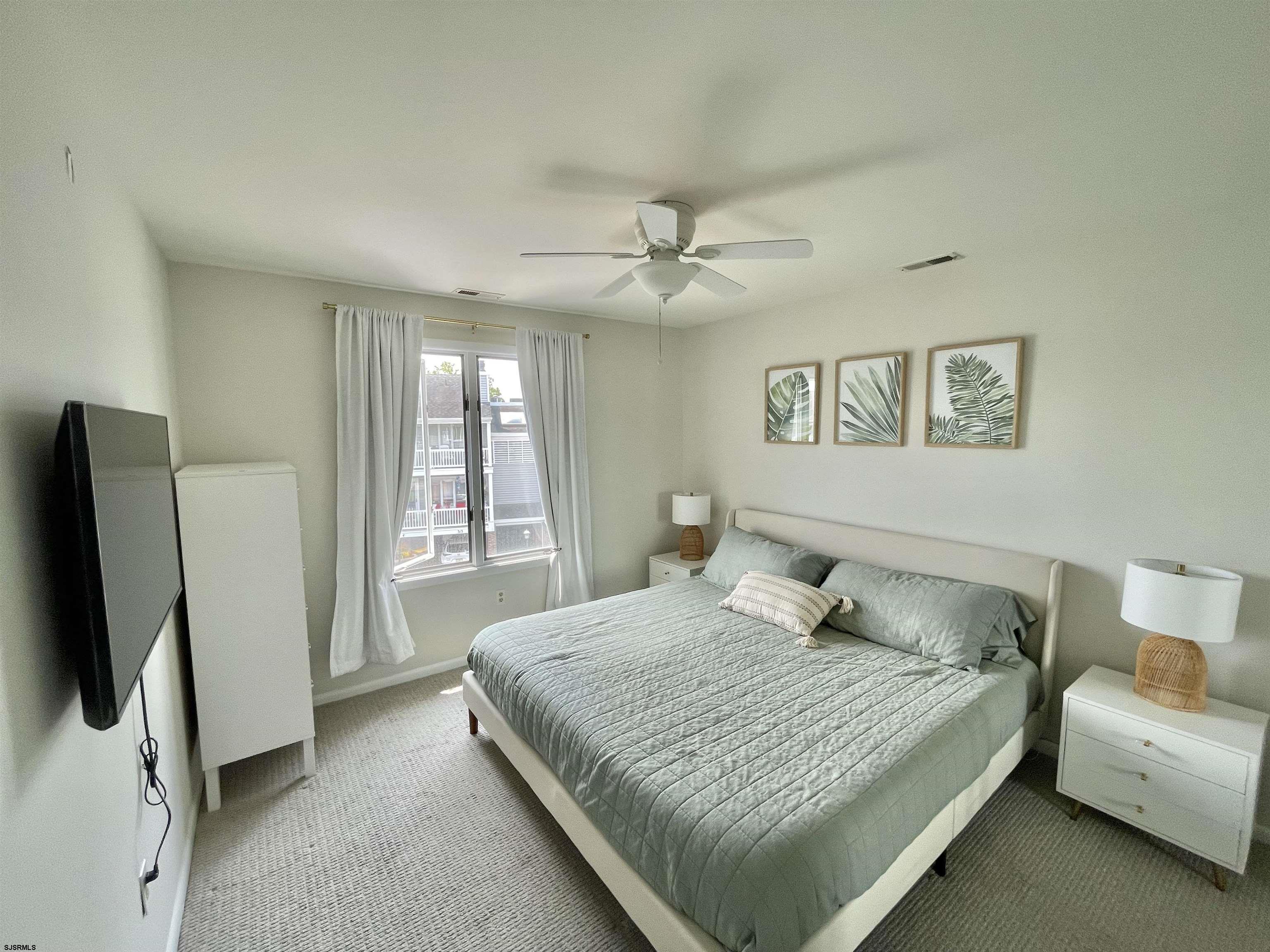 210 Harbour Cove, Unit 210 Somers Point, NJ 08244 - Photo 13 of 30 a bedroom with a bed flat screen tv and a couch