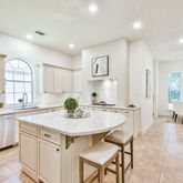 a kitchen with a sink chairs and cabinets