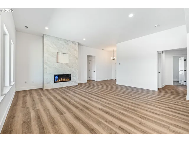 a view of empty room with wooden floor and fireplace
