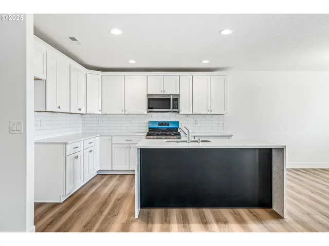 a kitchen with granite countertop a refrigerator and a stove
