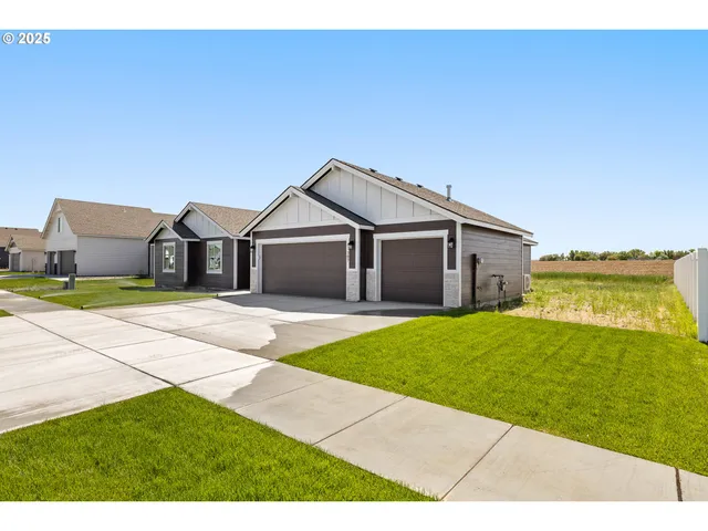 a front view of a house with a garden and yard