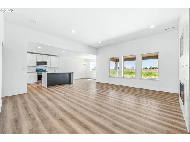 a view of empty room with kitchen and window