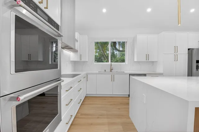 a large kitchen with stainless steel appliances and large counter top