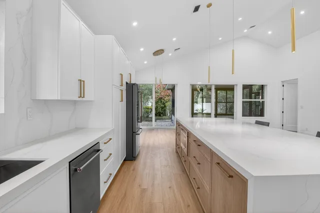 a large kitchen with kitchen island a sink table and chairs