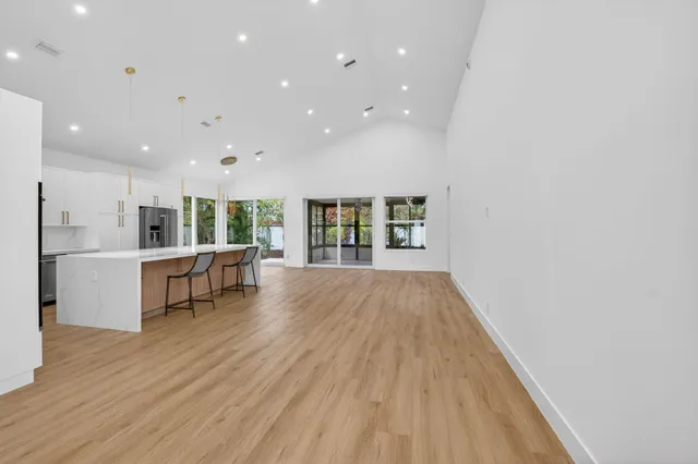 a kitchen with stainless steel appliances kitchen island granite countertop a refrigerator and a stove top oven