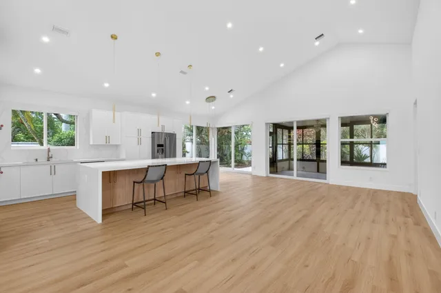 a kitchen with stainless steel appliances granite countertop a refrigerator a sink and a stove