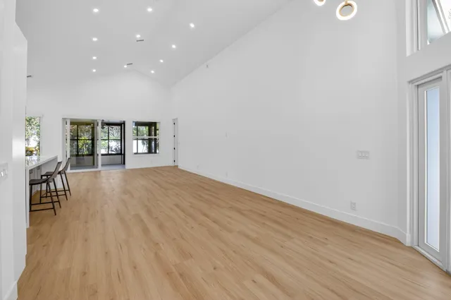 an empty room with wooden floor and a floor to ceiling window