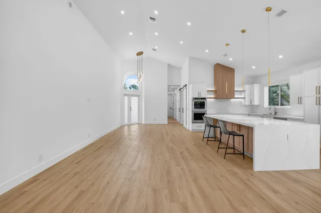 a large kitchen with stainless steel appliances a refrigerator and a stove top oven