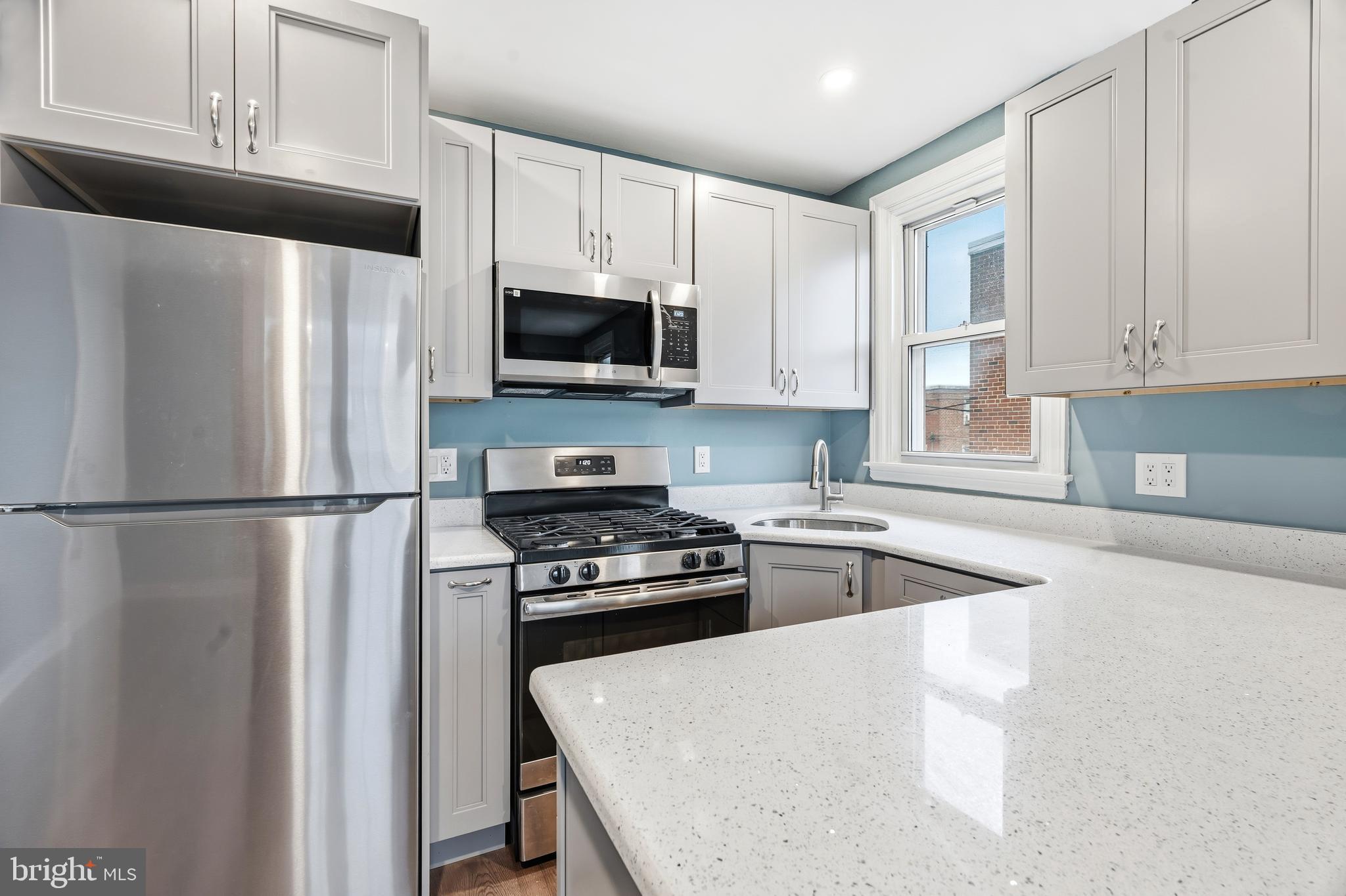 7318 Frontenac Street Philadelphia, PA 19111 - Photo 7 of 13 a kitchen with white cabinets and stainless steel appliances