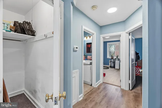 a view of an empty room with closet and wooden floor