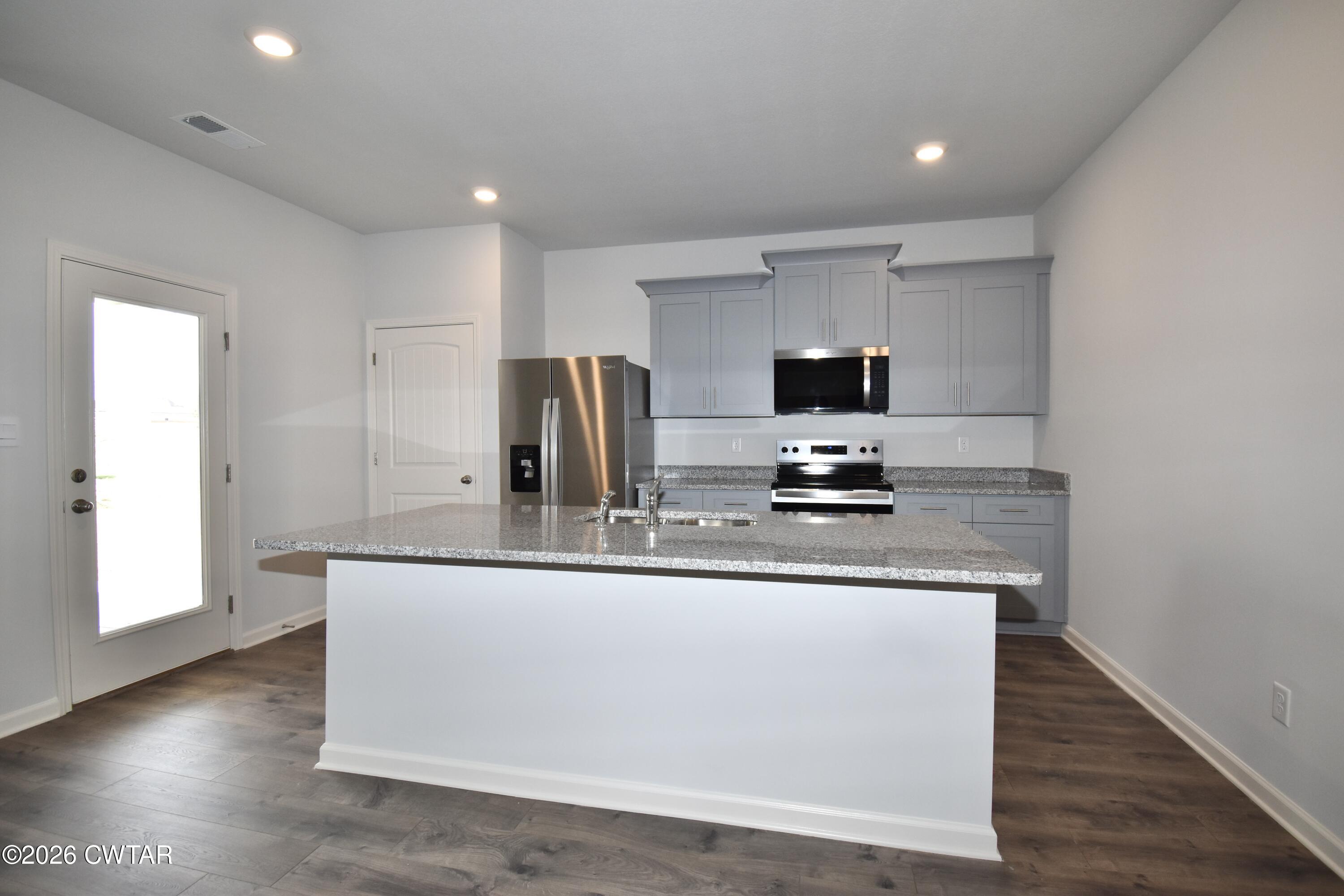 63 Clarendon Cove Jackson, TN 38305 - Photo 4 of 18 a kitchen with stainless steel appliances granite countertop a sink and a refrigerator