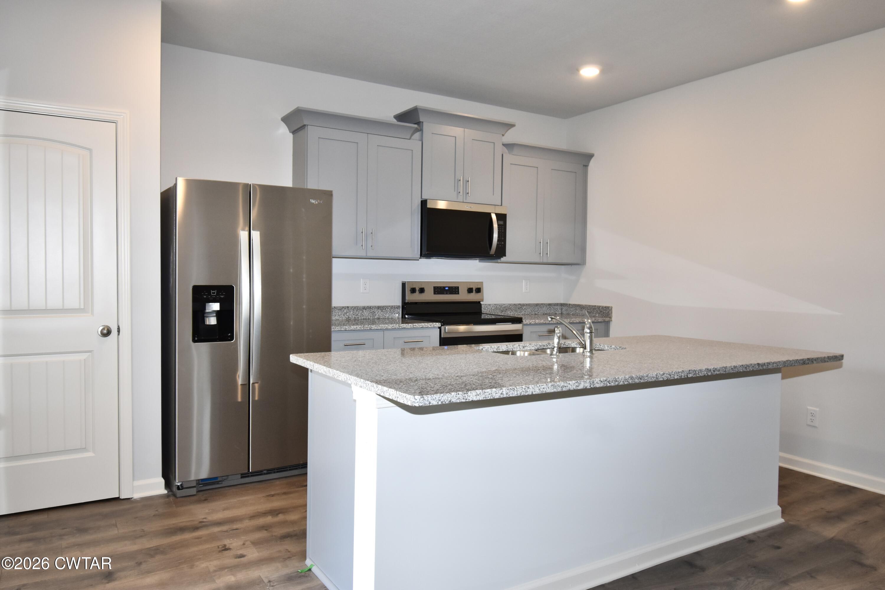 63 Clarendon Cove Jackson, TN 38305 - Photo 6 of 18 a kitchen with stainless steel appliances granite countertop a refrigerator a stove a sink and a microwave