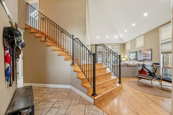 a large kitchen with stainless steel appliances granite countertop a large stove a sink dishwasher and white cabinets with wooden floor