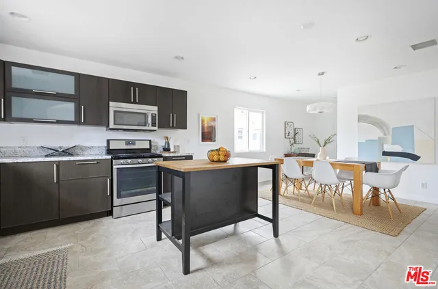 a living room with stainless steel appliances kitchen island granite countertop furniture and a kitchen view