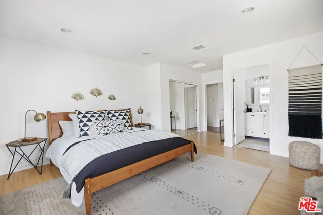 a bedroom with a bed and wooden floor