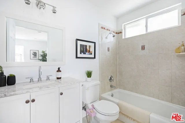 a bedroom with a bed a mirror and a window