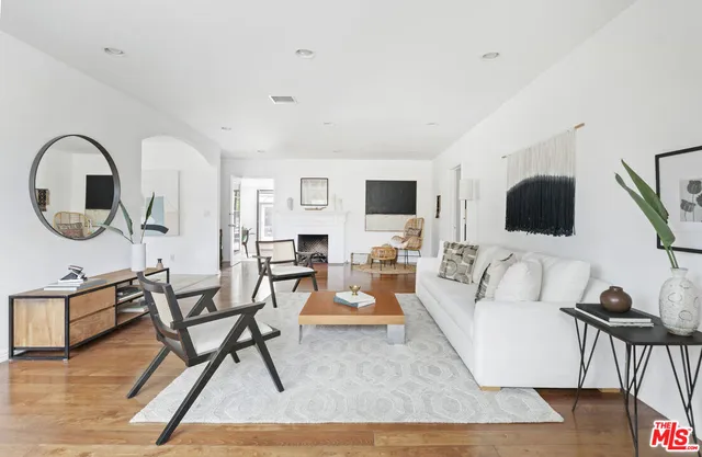 a living room with furniture a flat screen tv and a large window