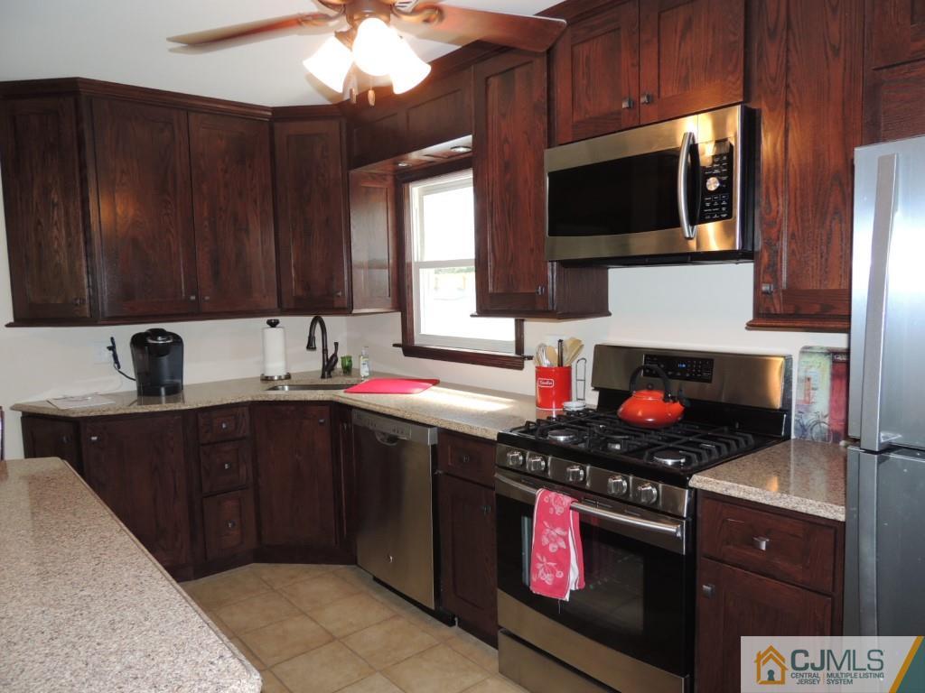7 Channing Road East Brunswick, NJ 08816 - Photo 4 of 11 a kitchen with stainless steel appliances a stove a microwave a sink and cabinets