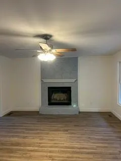 an empty room with wooden floor fire place