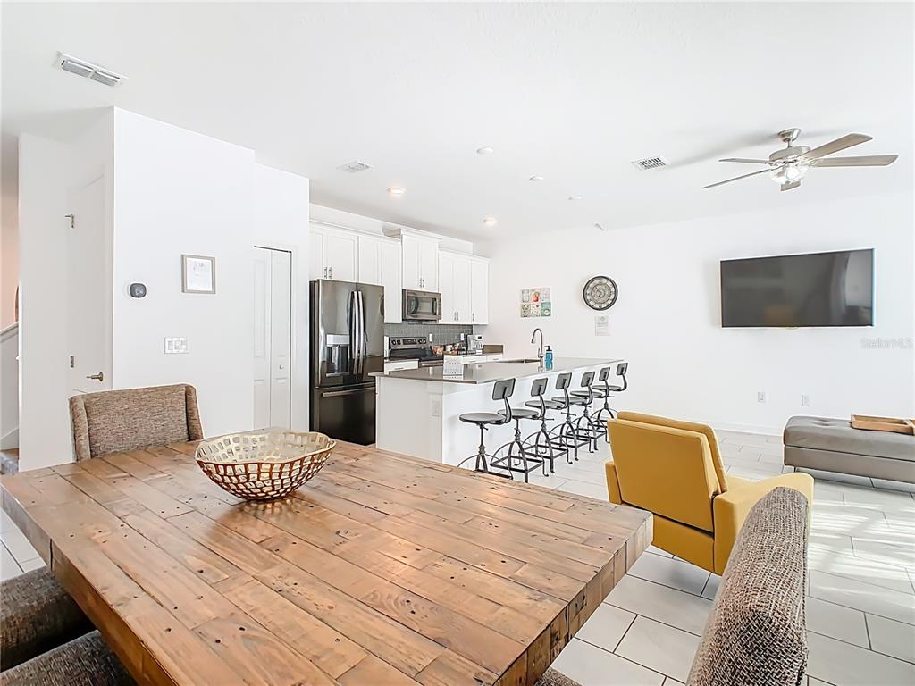 2957 Simile Street Kissimmee, FL 34746 - Photo 17 of 67 a kitchen with a table chairs refrigerator and microwave