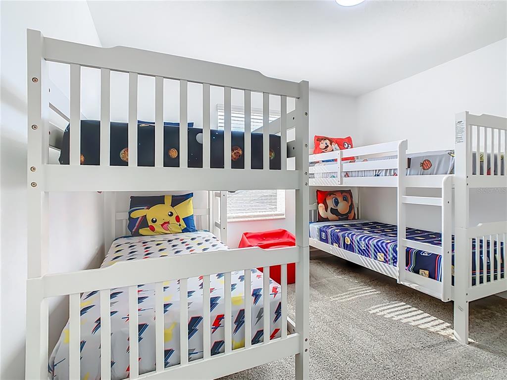 2957 Simile Street Kissimmee, FL 34746 - Photo 29 of 67 a bedroom with furniture a baby crib and a white wooden floor