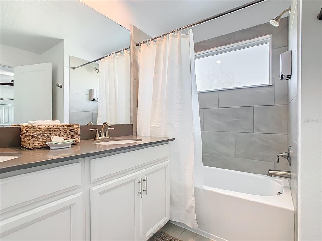 2957 Simile Street Kissimmee, FL 34746 - Photo 38 of 67 a bathroom with a granite countertop sink and a bathtub
