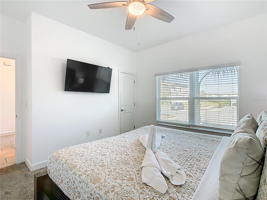 2957 Simile Street Kissimmee, FL 34746 - Photo 40 of 67 a bedroom with a bed and a flat screen tv